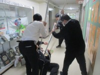 さすまたで不審者が動けないようにする