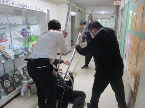 さすまたで不審者が動けないようにする